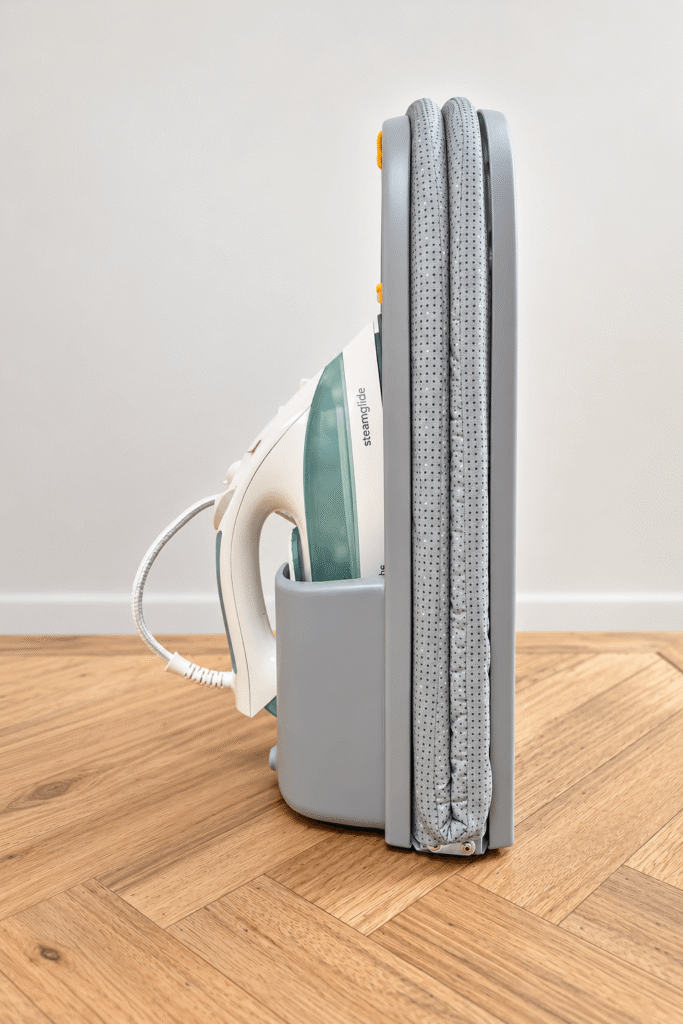 Folding ironing board with a space to store the iron.